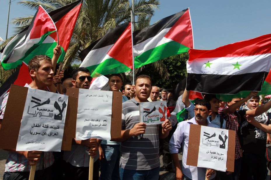 Palestinians, waving the Syrian and Palestinian national flags, demonstrate against possible Western military intervention in Syria in the West Bank city of Nablus on August 29.