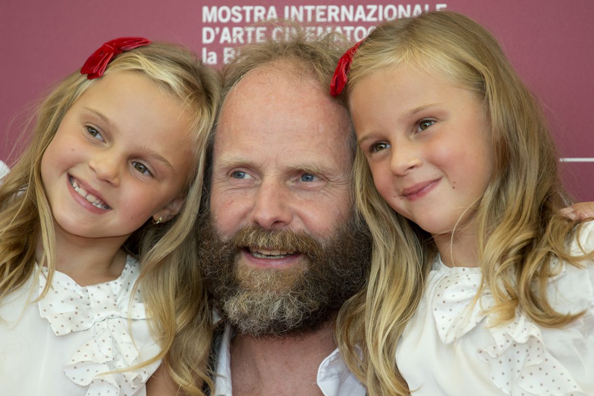 Twins Pia Keelman, left, and Chiara Keelman pose at the festival with director Philip Groning for the film "The Police Officer's Wife" on August 30.