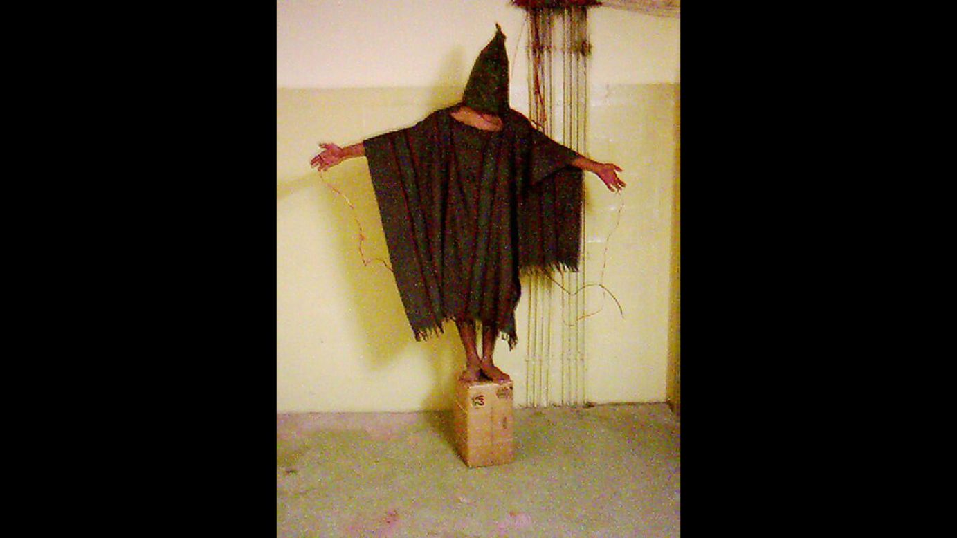 A hooded detainee in U.S. custody during the Iraq War stands on a box with electrical wires hooked up to his fingers. The image became a symbol of the Abu Ghraib prison abuse scandal after it was released, among others, in late April 2004. It did what a written report could not do, showing front-and-center what human rights groups had been saying for months: that prisoners were being abused at the hands of U.S. troops. The fallout was immediate, both overseas and at home.
