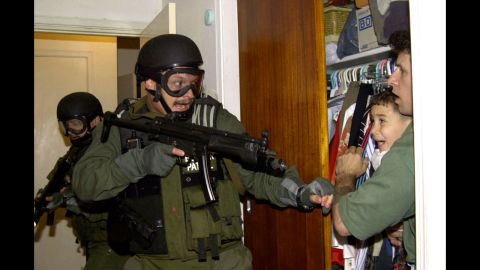 During a raid at a Miami home in 2000, armed federal agents confront Elian Gonzalez, 6, and one of the men who helped rescue the boy. Gonzalez watched his mother drown when the boat smuggling them from Cuba capsized. Under international law, U.S. authorities were required to return the boy to his father in Cuba. Alan Diaz's photograph of the saga's defining moment won a Pulitzer Prize. "The cry I heard that day I had never heard in my life," <a href="http://articles.sun-sentinel.com/2010-04-22/news/fl-elian-photographer-20100422_1_cry-elian-gonzalez-haunted" target="_blank" target="_blank">Diaz said a decade later</a>. "A cry like that will haunt anyone forever."