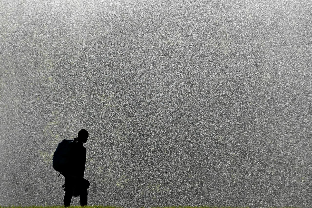 A man refreshes in front of a sprinkler in the Tiergarten park in Berlin on Monday, August 26. Weather forecasts predict changeable weather for Germany.  