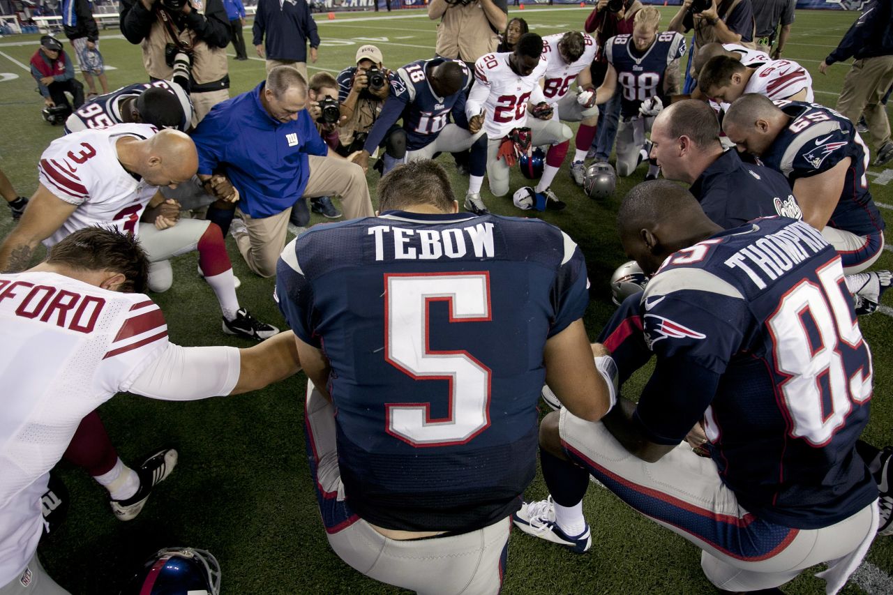 Tebow prays with his New England Patriots teammates and members of the New York Giants after a preseason game in Foxborough, Massachusetts, in 2013. Tebow has always been outspoken about his Christian faith.