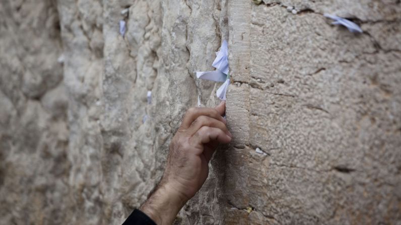 A man sticks a note into the Western Wall. This is part of the original Jewish temple complex in the Old City.