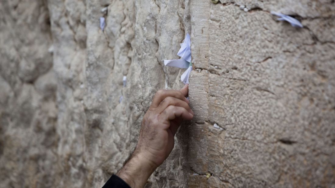 A man sticks a note into the Western Wall. This is part of the original Jewish temple complex in the Old City.