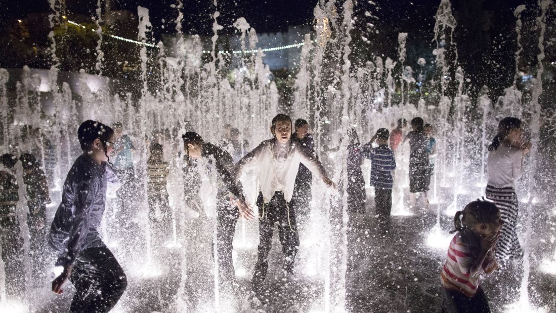 Children play in a fountain at a park in Jerusalem.