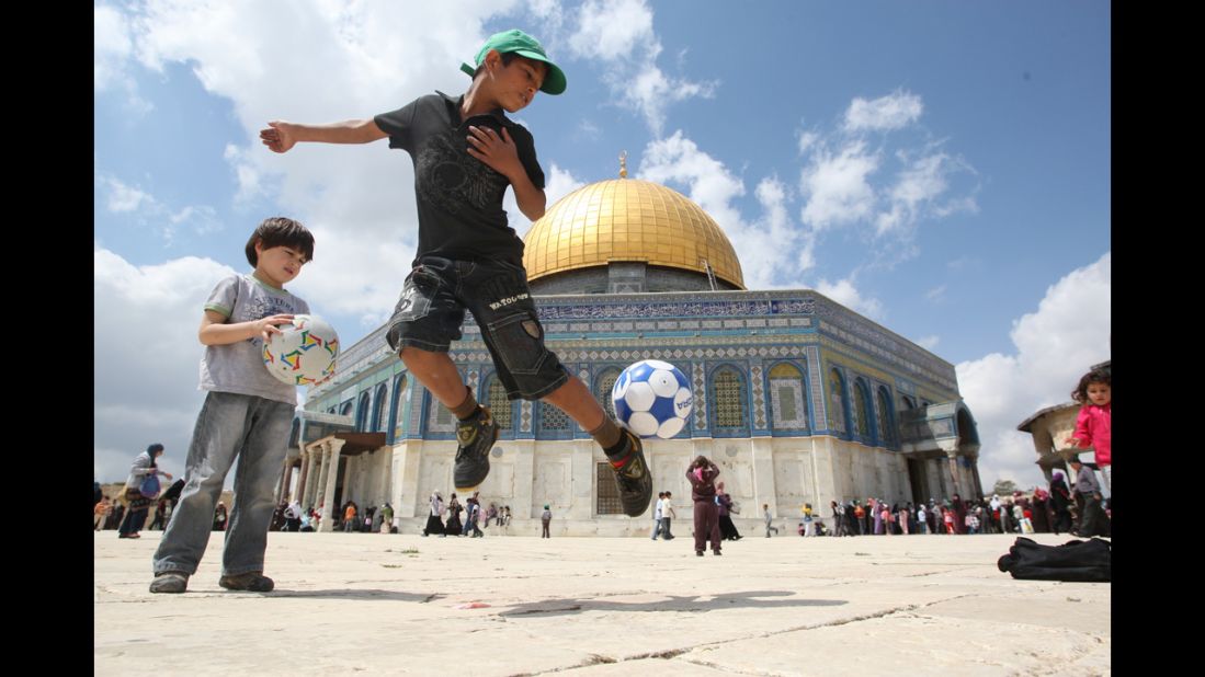 Daily life in Jerusalem: A boy plays with a soccer ball in front of the Dome of the Rock. It's one of several key religious sites, all contained within a tiny area, making anyone's first visit to the Old City unforgettable.