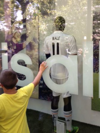 A young fan paws the window of the Real Madrid shop showcasing Gareth Bale's new shirt. 