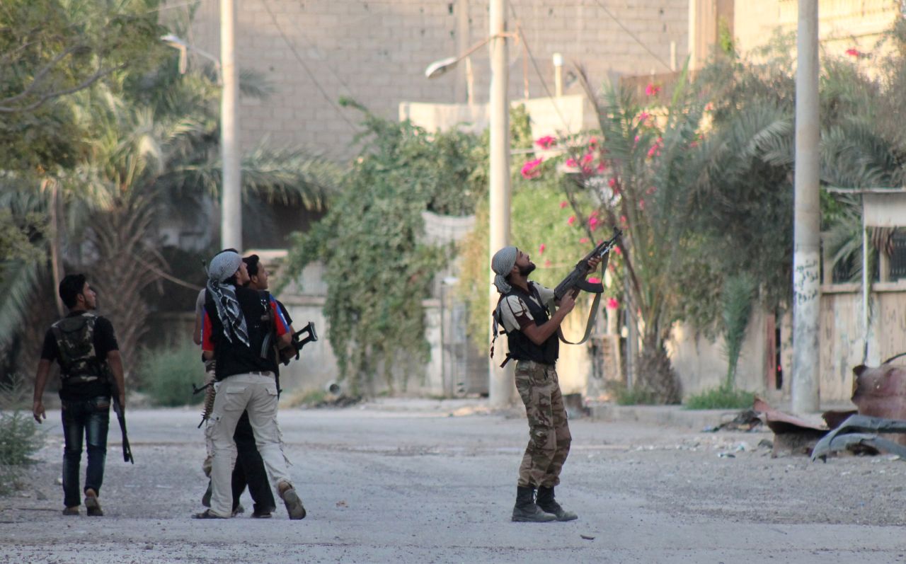 A rebel fighter points his weapon at Syrian regime forces in Deir ez-Zor on September 2.