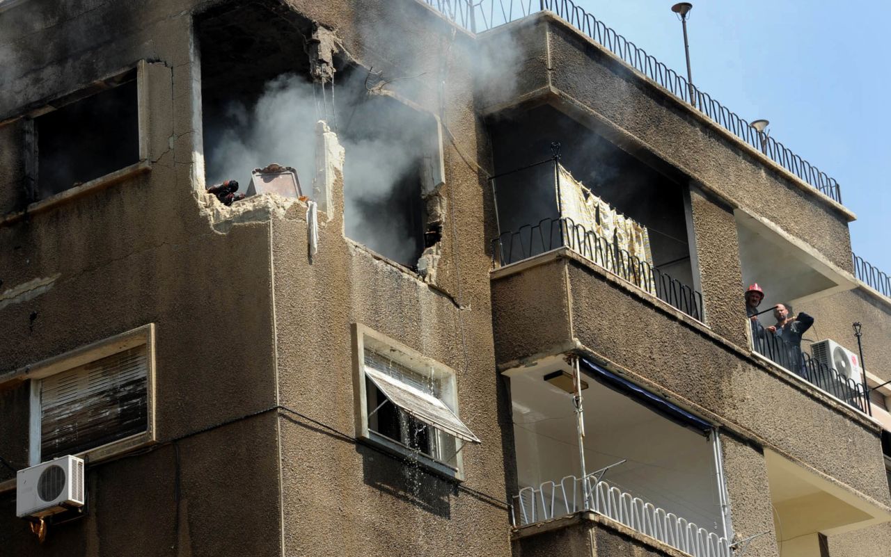 Syrian firefighters try to extinguish a fire after a missile hit a residential building in Damascus, Syria, on September 2.