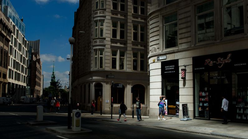 A man shades his eyes in a shaft of intense sunlight reflected from the glass windows of the building on August 30.