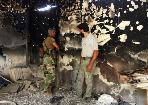 Free Syrian Army fighters talk inside a burnt house in Aleppo on September 3.
