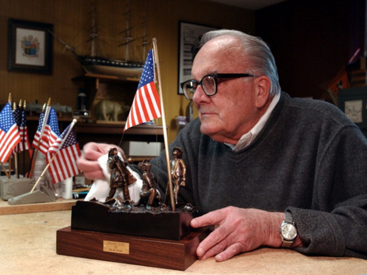 Artist Jim Conrad designed a sculptured bronze version of the flag raising in honor of the Rev. Mychal Judge, a New York Fire Department chaplain who lost his life while administering last rites on September 11, 2001. Conrad is seen polishing the sculpture in 2002 at his home in Lakewood, Colorado.