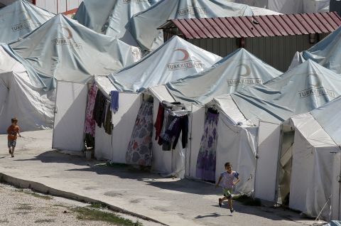 Children run past tents at a Syrian refugee camp in Yayladagi, Turkey, in September 2013.