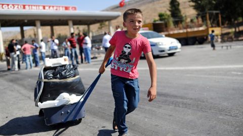 A child pulls a suitcase as Syrian refugees arrive at the Cilvegozu crossing gate in Turkey in August 2013.