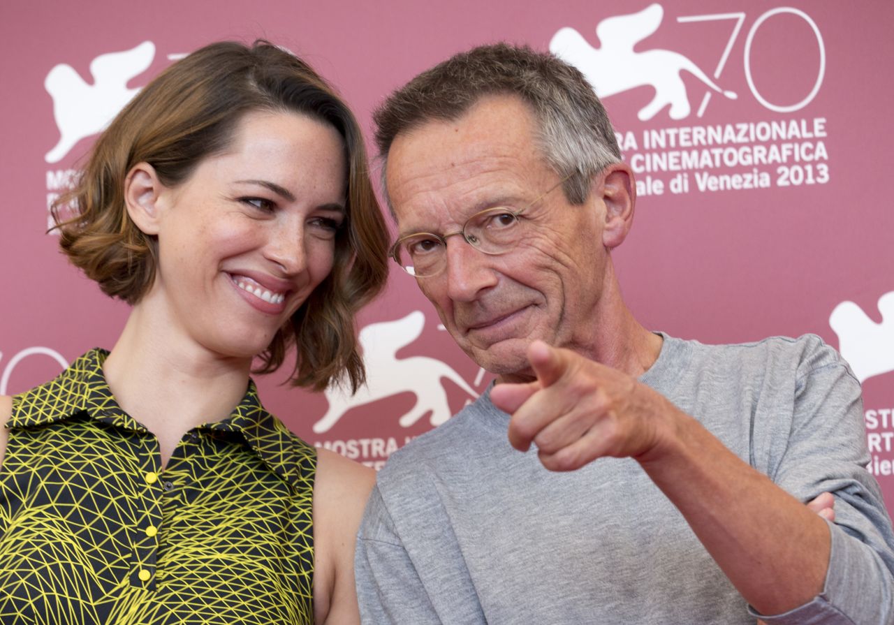 Director Patrice Leconte, right, points at photographers while posing with actress Rebecca Hall during the photo call for the film "A Promise" on September 4.