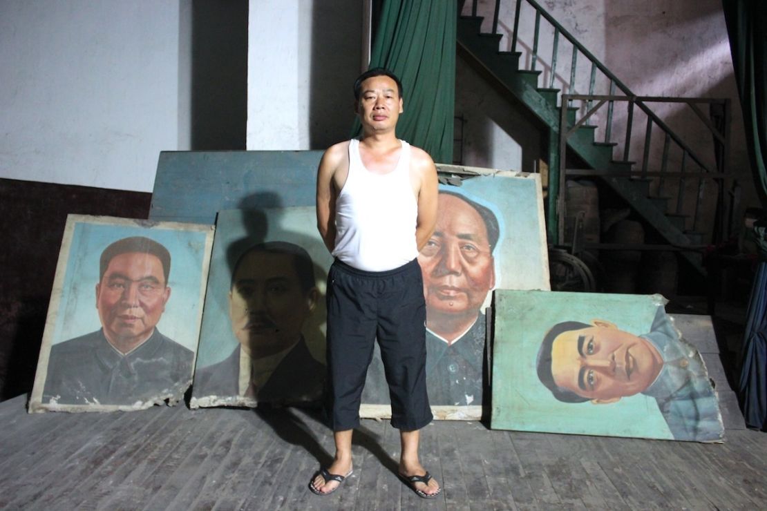 A superintendent of the former Workers' Theatre proudly looks after old images of Hua Guofeng, Sun Yatsen, Mao Zedong and Zhou Enlai.