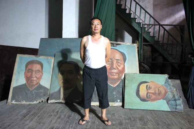 A superintendent of the former Workers' Theatre proudly looks after old images of (L-R) Hua Guofeng, Sun Yatsen, Mao Zedong and Zhou Enlai.