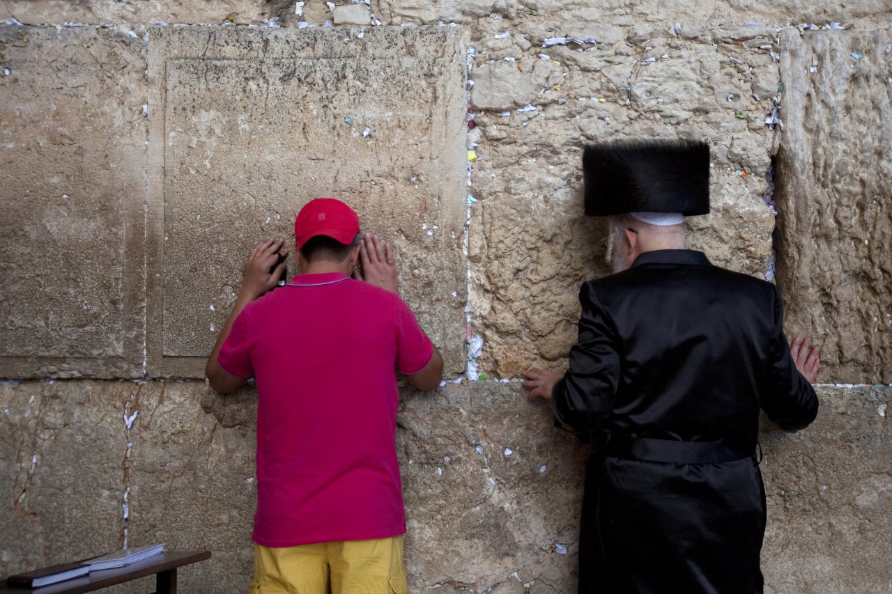 A tourist prays alongside an Orthodox Jewish man at the Western Wall on September 4.