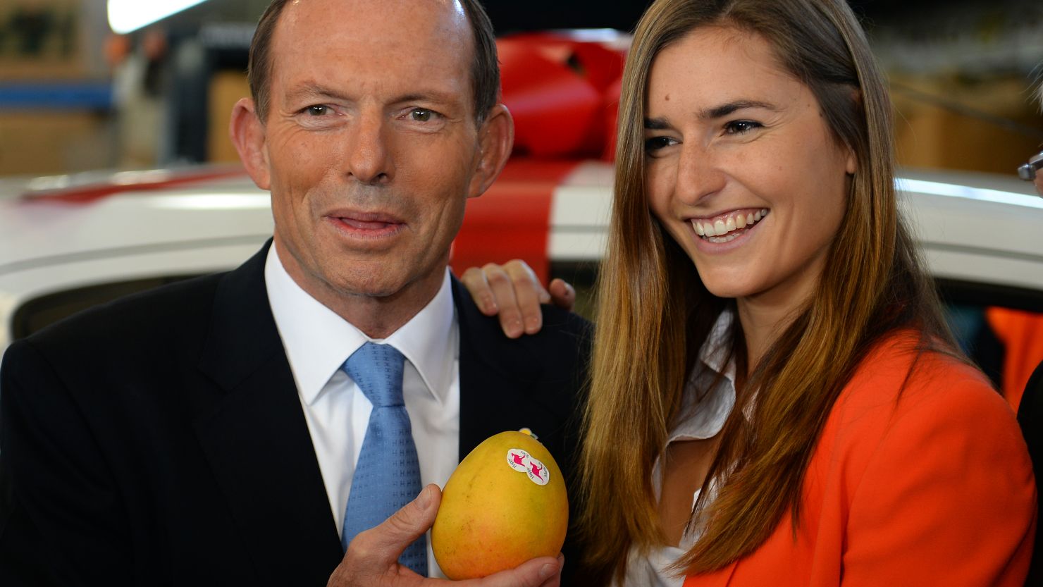 Australian opposition leader Tony Abbott poses with a mango and one of his "not bad looking daughters." What will he say next?