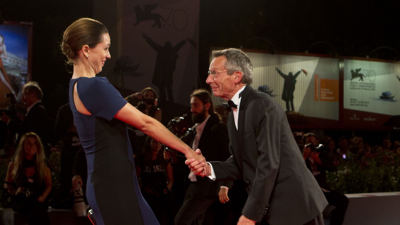 Director Patrice Leconte and actress Rebecca Hall of the film "A Promise" have fun on the red carpet on September 4.