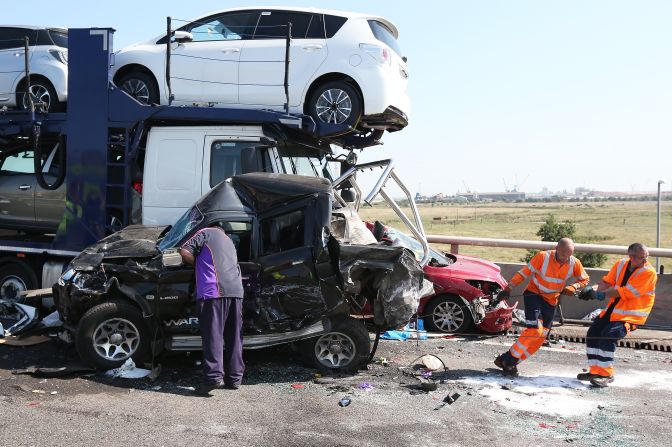 Vehicle recovery workers try to move a vehicle on the scene. 