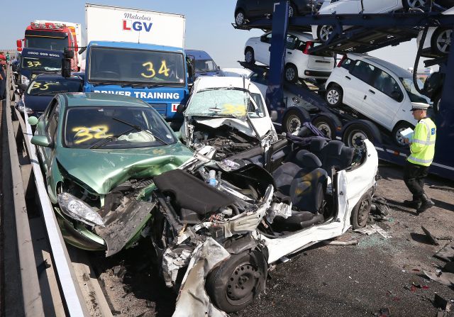 A police officer inspects the site of the major traffic accident. At least 100 vehicles smashed into each other in a massive pileup on Thursday, September 5, on a multilane bridge and highway in England's southeastern county of Kent, police said, injuring eight people seriously and leaving dozens with minor injuries.