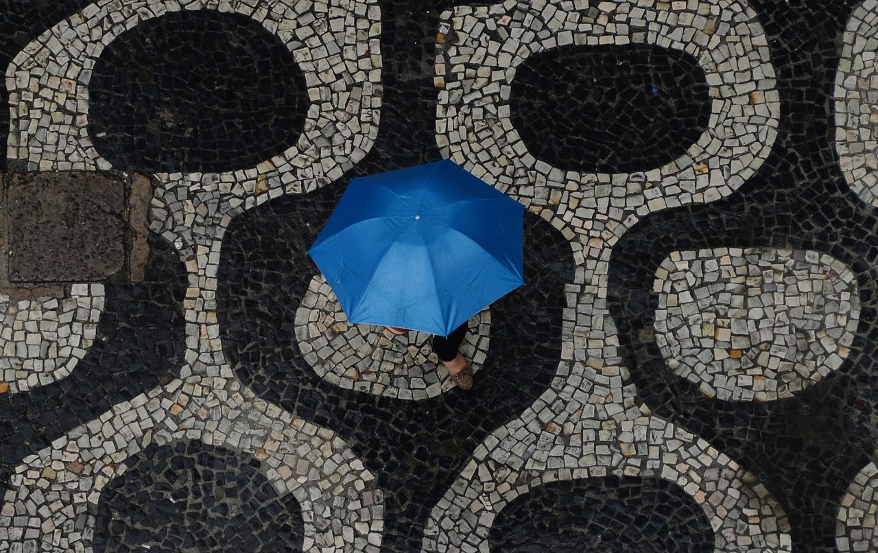 A pedestrian walks in the rain on a street in Rio de Janeiro on September 4.