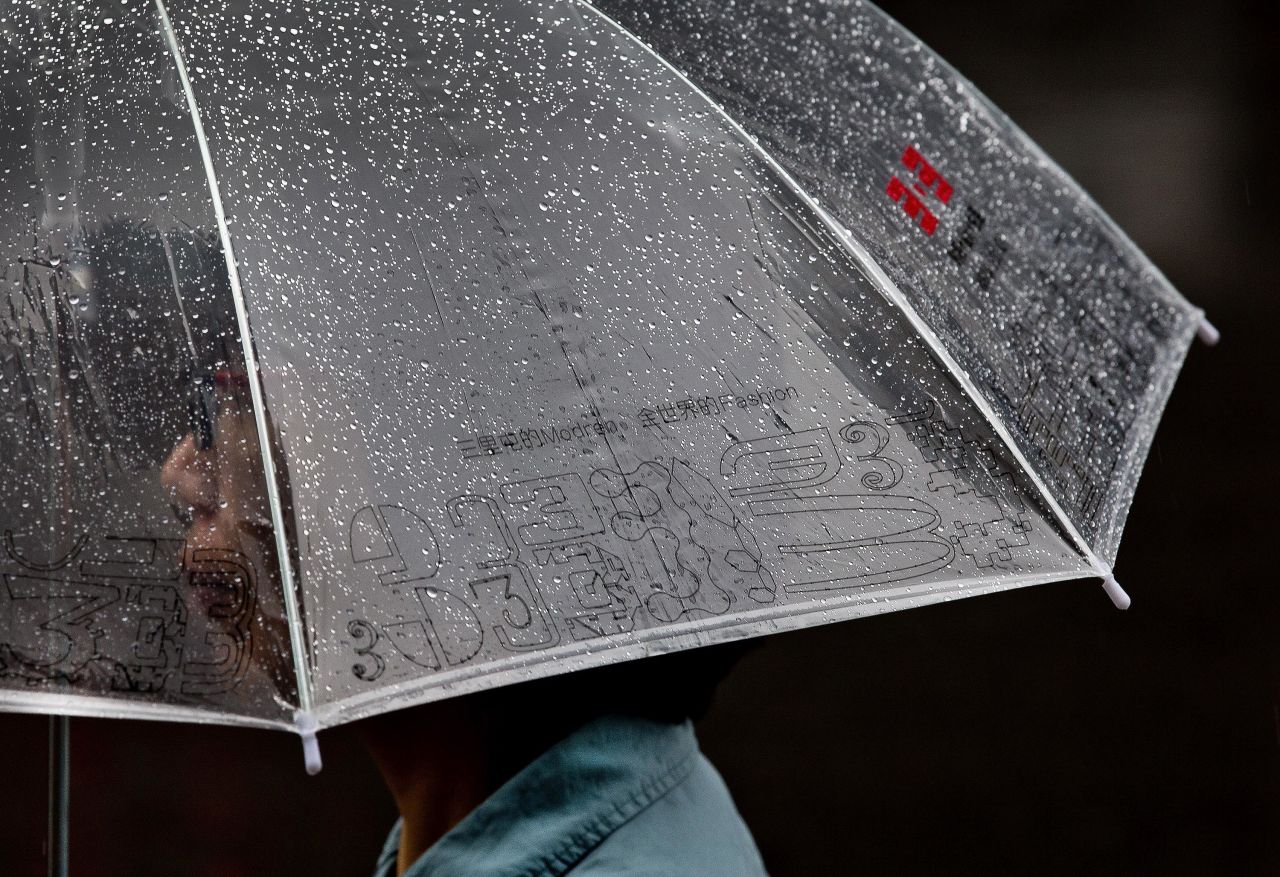 A woman holding an umbrella walks in the rain in Beijing on September 4.