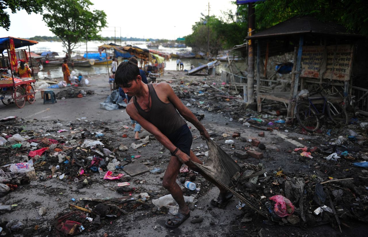 An Indian man clears debris from the banks of the Ganga River as floodwaters recede in Allahabad on September 3.