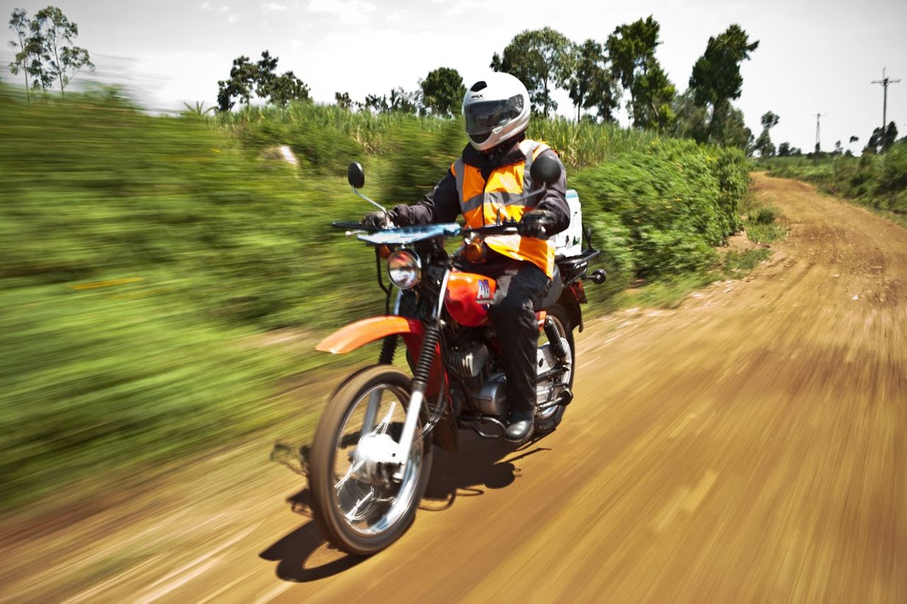 Joel Otieno, a clinical health assistant at the FACES community-based organization in Kenya, rides to his next appointment. He is supported by an organization called Riders for Health, founded by Andrea and Barry Coleman, who share a passion for motorcycles. Through the racing world, they became involved in fundraising for children in Africa and soon recognized the vital role of transportation in providing health care.