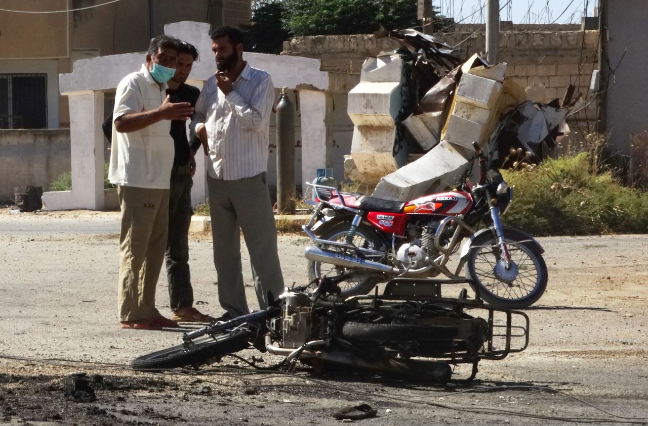 Hombres observan los restos de una moto en la provincia siria de Idlib el 5 de septiembre.