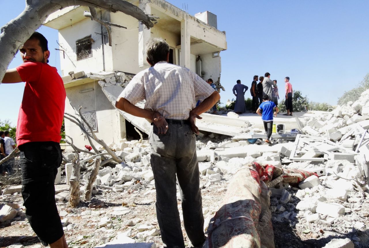 Men gather on the remains of a destroyed building after reported airstrikes by Syrian government forces in the rebel-held northwestern Syrian province of Idlib on Thursday, September 5. 