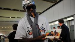 Former US basketball player Dennis Rodman shows pictures of him reportedly with North Korean leader Kim Jong-Un to media as he arrives at Beijing International Airport on September 7, 2013. Rodman returned to China from Pyongyang on September 7 after a five-day trip when he met Kim Jong-Un, but without jailed American Kenneth Bae.