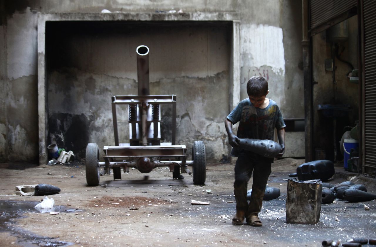 Un chico llamado Issa, de 10 años, carga una granada de mortero en una fábrica de armas del Ejército Libre de Siria en Aleppo el sábado, 7 de septiembre. El niño trabaja con su padre en la fábrica.