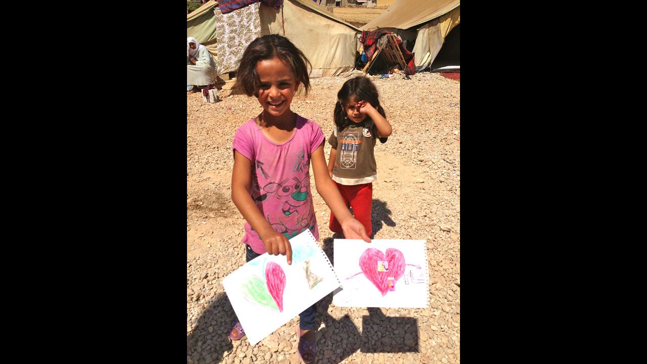 At a makeshift refugee area, just half a mile from the Syrian border, two young girls colored pictures and sang songs. They both left Syria without their parents. 