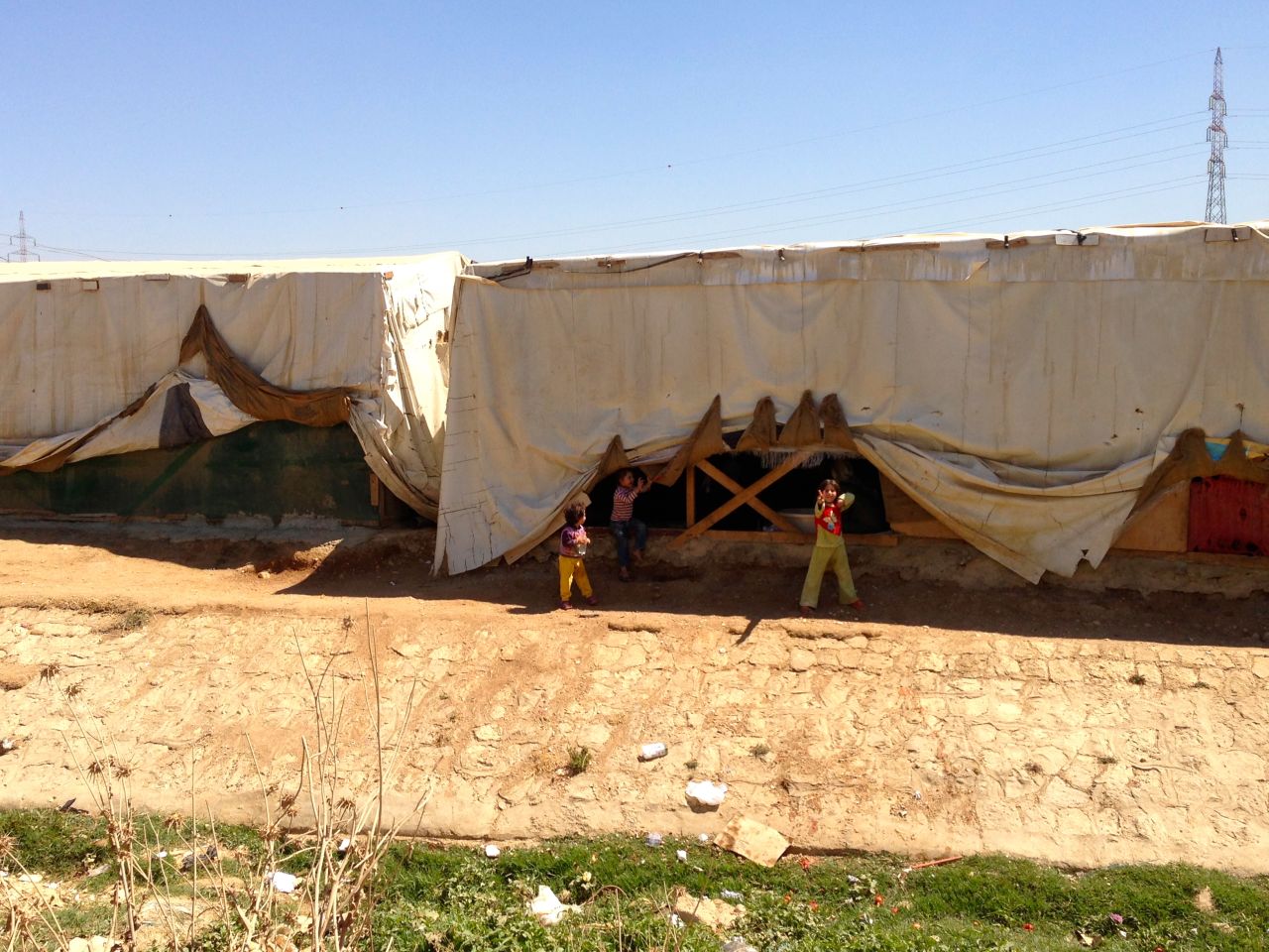 According to aid group workers, the sheriff in this Lebanon border town near Syria charges the refugees who set up shelter in the dirt here $100 a month. 