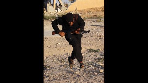 A Free Syrian Army fighter runs for cover in Raqqa province on September 8.