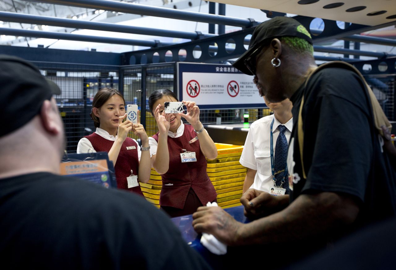 Airport staff take pictures of the former NBA star at a check-in counter in Beijing in September 2013.