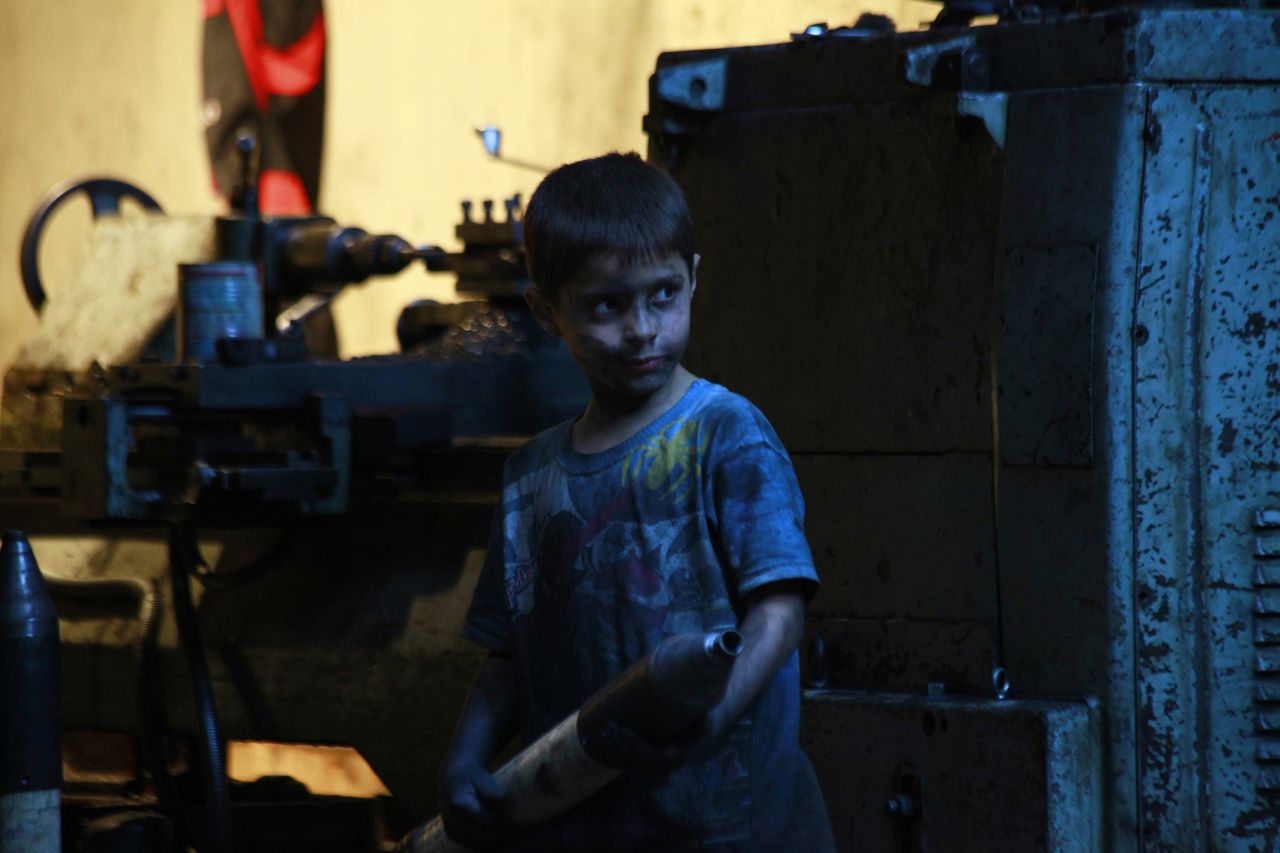 Issa pauses with a mortar shell in hand while working in the weapons factory.