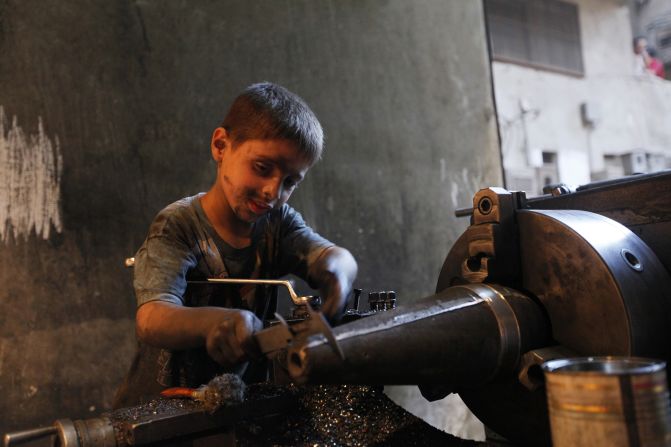 Issa measures a mortar shell on a machine.