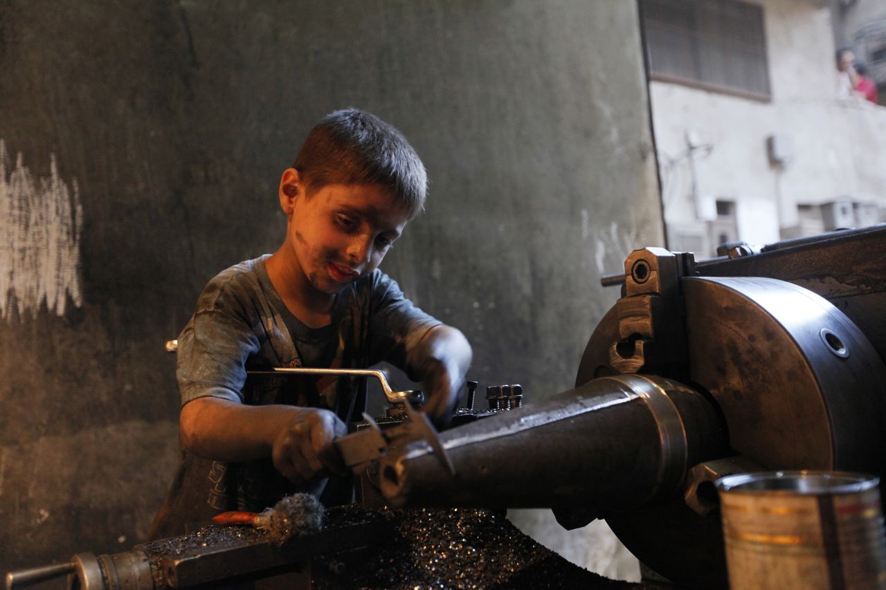 Issa measures a mortar shell on a machine.