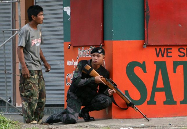 A combat police force sniper gets into position to confront Moro National Liberation Front (MNLF) rebels in downtown Zamboanga City on September 9.