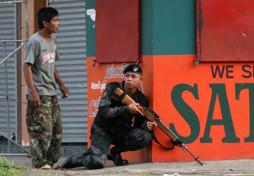 A combat police force sniper gets into position to confront Moro National Liberation Front (MNLF) rebels in downtown Zamboanga City on September 9.