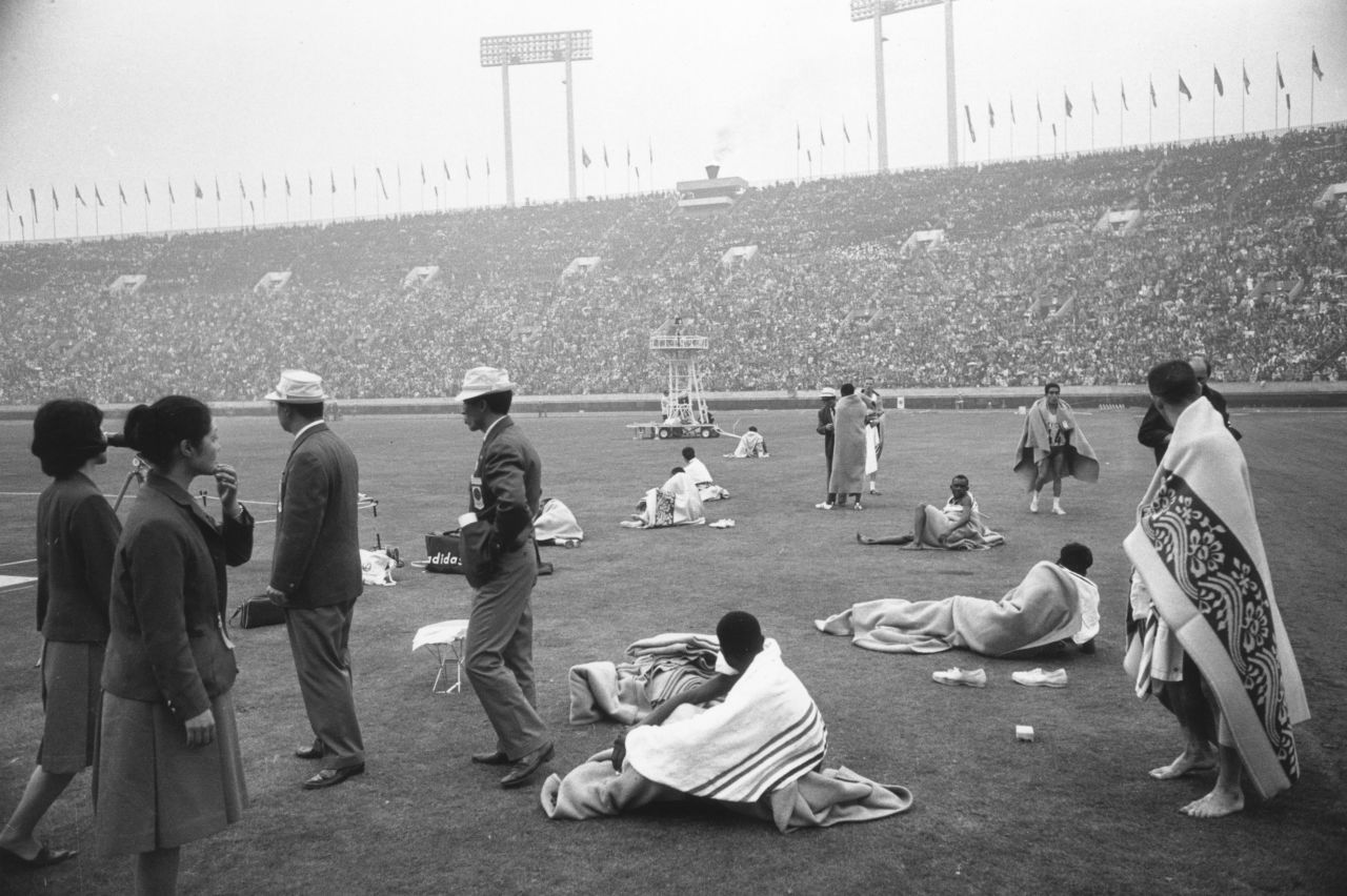 October 21, 1964: Marathon runners keep warm in patterned blankets after the race.