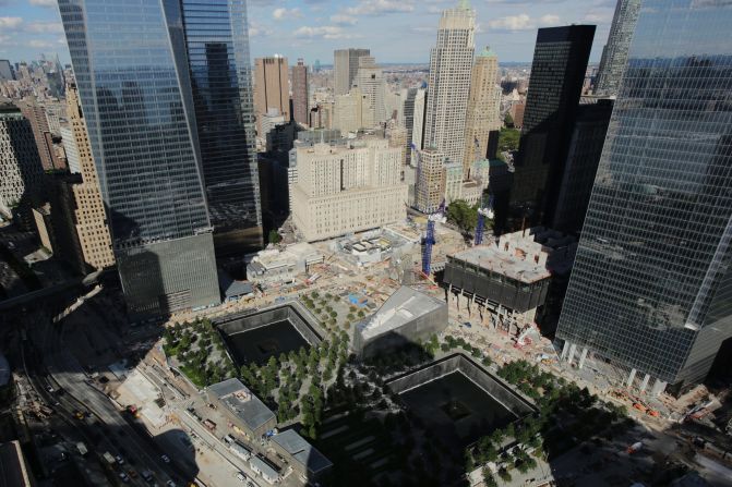 The wedge-shaped pavilion entrance of the museum, center, is located between the square outlines of the memorial waterfalls at the World Trade Center.