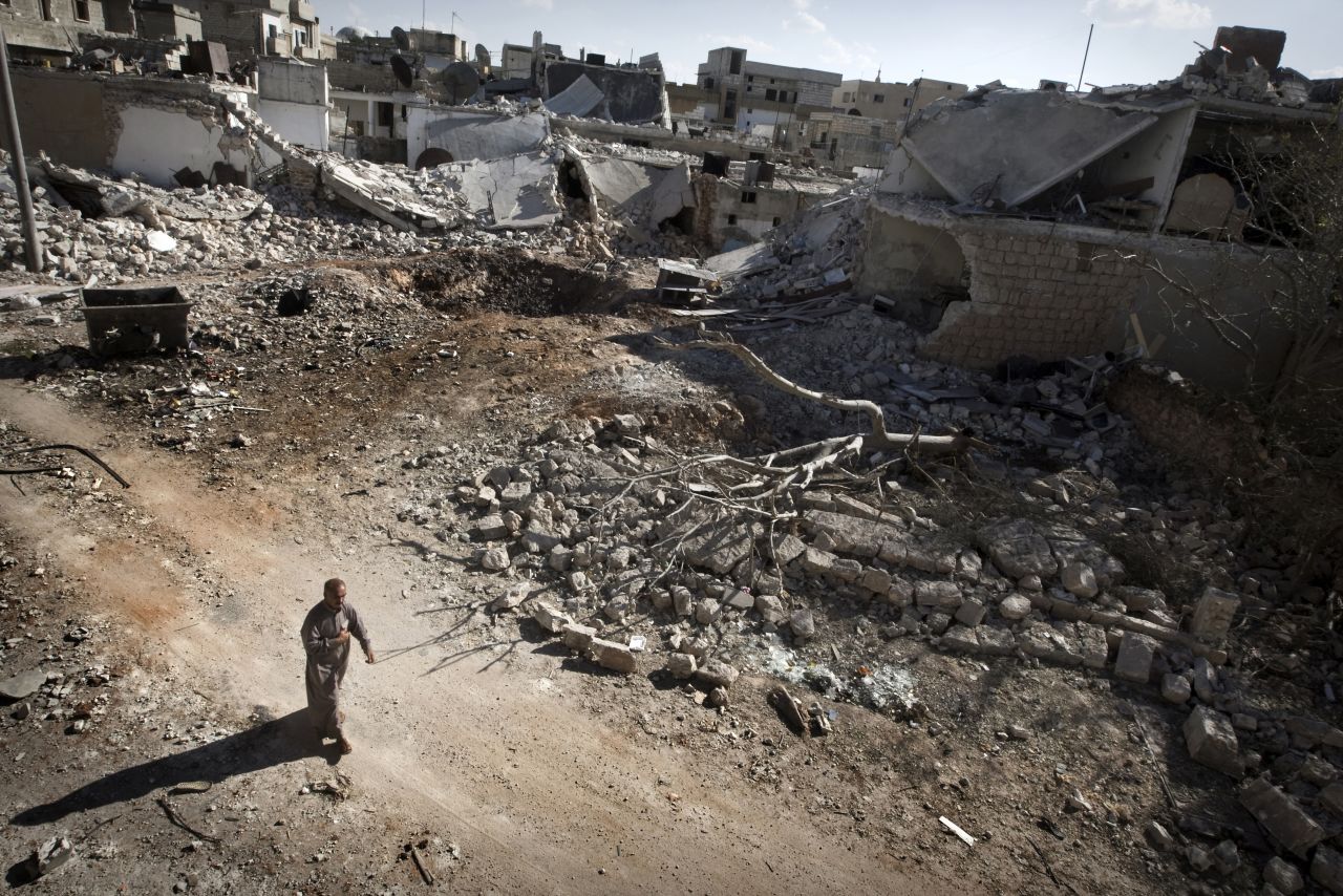 A man walks through a destroyed residential area of Saraqib, Syria, on Monday, September 9, following repeated airstrikes by government forces.