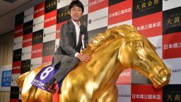 Japanese leading jockey Yutaka Take poses on a life-sized statue of the Japanese legendary 'Oguri Cap' horse, which won four grade-one (G1) races and died in 2010, made from fiber rainforced plastic (FRP) and coated with gold foil is displayed at the opening of the Gold Expo event at Tokyo's Mitsukoshi department store on July 11, 2013. The exhibition will display and sell a total of 100 million USD (10 billion yen) gold made products, including the gold horse, priced at 201,400 USD (20.14 million yen). AFP PHOTO / Yoshikazu TSUNO (Photo credit should read YOSHIKAZU TSUNO/AFP/Getty Images) 