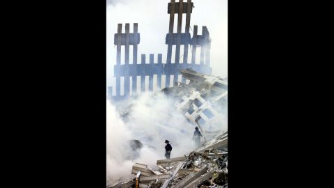 Firefighters stand in the smoldering wreckage of the World Trade Center on September 13, 2001.