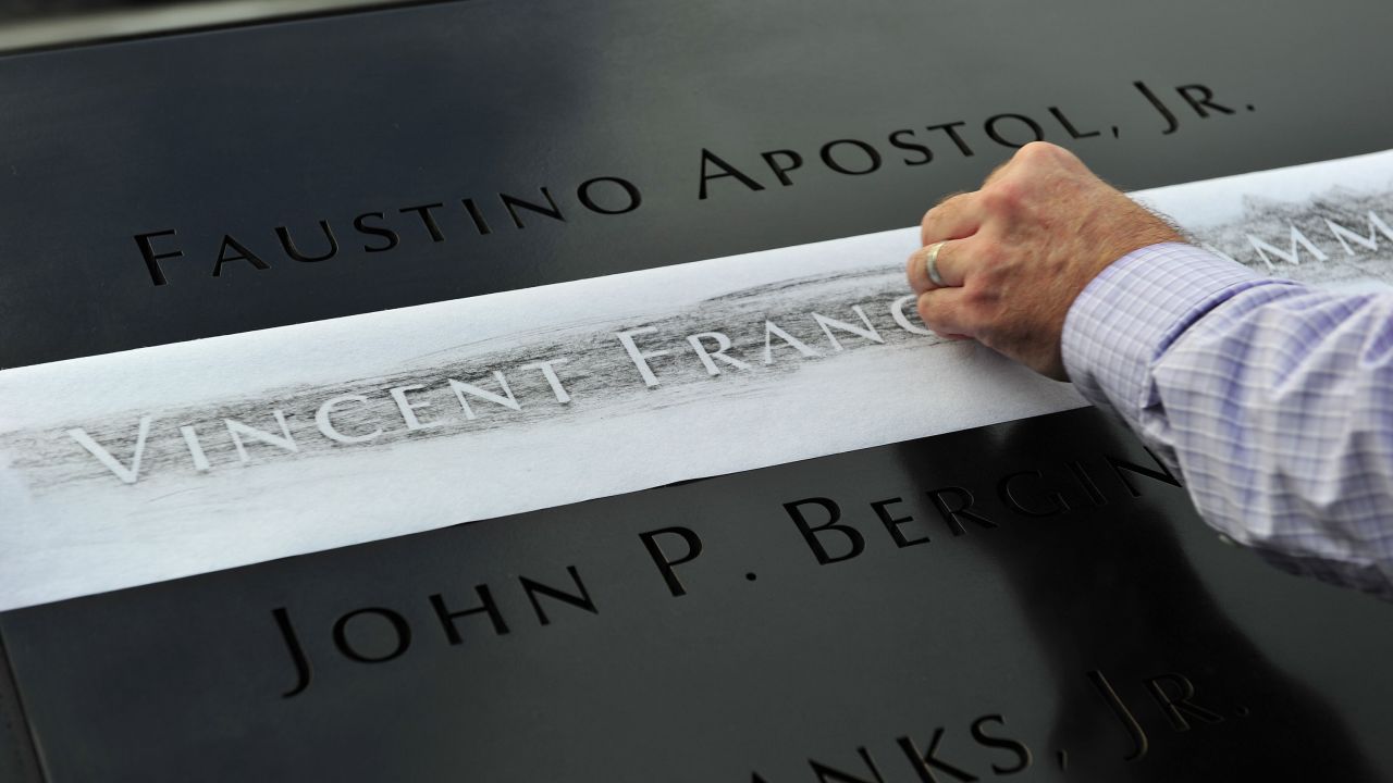 A man makes a rubbing of his friend's name, New York firefighter Vincent Giammona, at the south pool of the 9/11 Memorial on September 11.