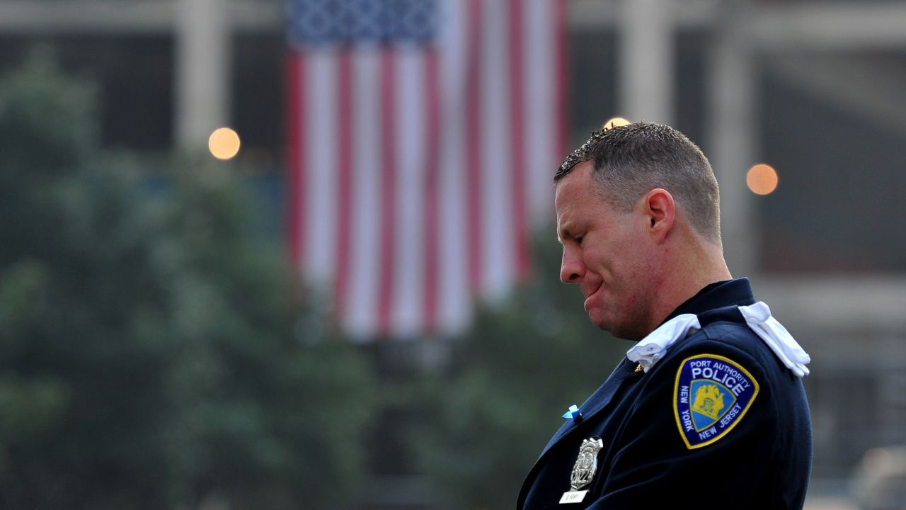 Daniel Henry, a police officer with the Port Authority of New York and New Jersey, pauses during a moment of silence at the south reflecting pool of the 9/11 Memorial in New York on September 11.